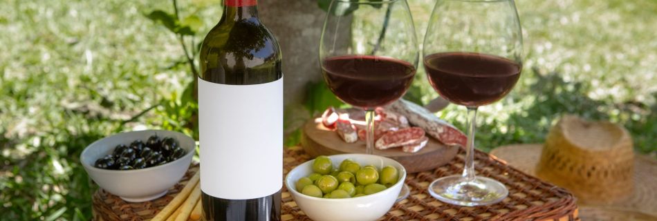 Bouteille et verres de vin sur un panier de pique-nique - Freepik