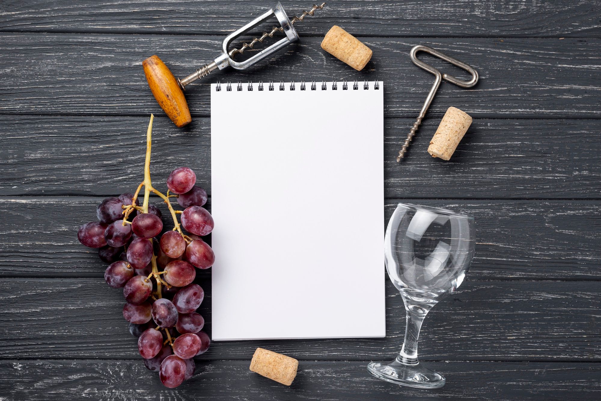 Carnet avec grappe de raisin, tires-bouchon et verre de vin - Freepik